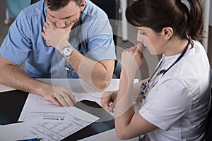 Surgeons analysing patient clinical documentation