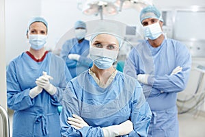 Surgeons with a commitment to excellent care. Portrait of a group of surgeons wearing hospital scrubs, face masks and