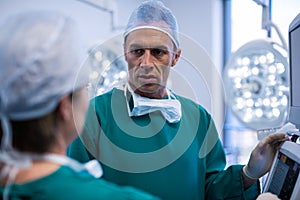 Surgeons discussing over medical reports in operation room