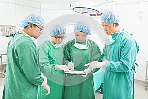 Surgeons discussing patient records in operation room