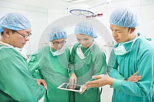 Surgeons discussing with tablet in operation room