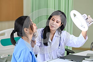 Surgeons examine a patient in preparation with directing lamp for cosmetic surgery in doctor office. Facial treatment, massage,