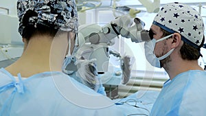 Surgeons perform a complex operation using a microscope