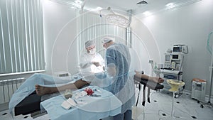 Surgeons perform operation under anesthesia. Action. Two professional surgeons perform operation under anesthesia in