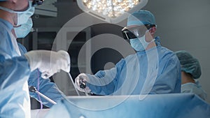 Surgeons in protective glasses use laparoscope