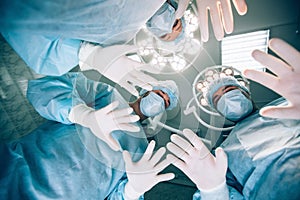 Surgeons standing above of the patient before