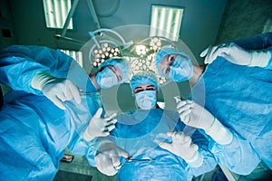 Surgeons standing above of the patient before