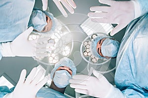 Surgeons standing above of the patient before