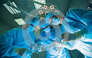 Surgeons standing above of the patient before