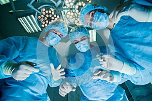 Surgeons standing above of the patient before