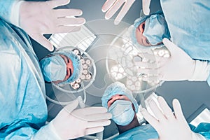 Surgeons standing above of the patient before surgery