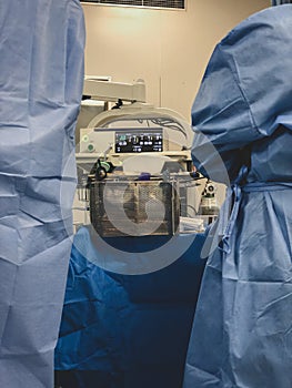 Surgeons using surgical instruments for keyhole surgery, watching the monitor which displays images from inside the patient`s abdo