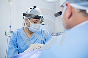 Surgeons wearing surgical loupes while operating patient