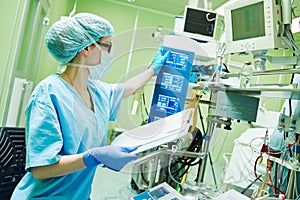 Surgery assistant perfusionist operating a modern heart lung machine