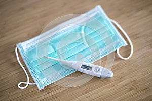 Surgical ear-loop mask and thermometer