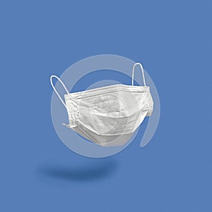 Surgical face mask on color background photo
