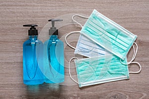 Surgical face masks and alcohol hand sanitizer gels for protecting covid-19 virus inflection on wooden background