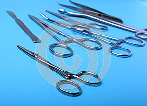 Surgical instruments and tools including scalpels, forceps and tweezers arranged on a table for a surgery.