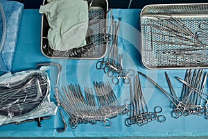 Surgical instruments and tools including scalpels, forceps and tweezers arranged on a table for a surgery