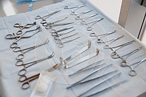 Surgical instruments and tools including scalpels forceps and tweezers arranged on table for surgery