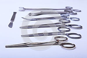 Surgical instruments and tools including scalpels, forceps tweezers arranged on a table for surgery