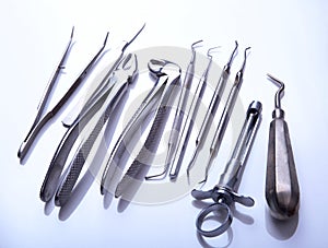 Surgical instruments and tools including scalpels, forceps tweezers arranged on a table for surgery