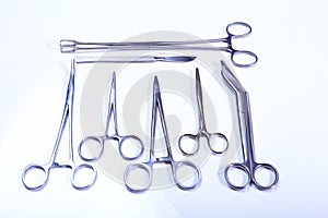 Surgical instruments and tools including scalpels, forceps tweezers arranged on a table for surgery