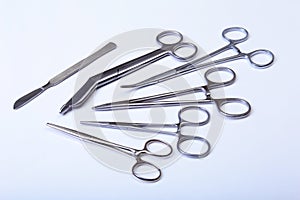 Surgical instruments and tools including scalpels, forceps tweezers arranged on a table for surgery