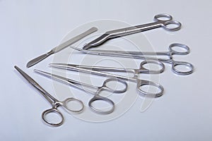 Surgical instruments and tools including scalpels, forceps tweezers arranged on a table for surgery