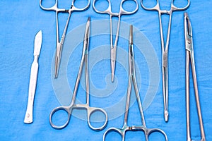 Surgical instruments and tools including scalpels, forceps and tweezers arranged on a table for a surgery