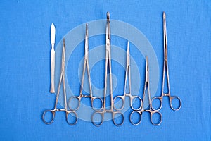 Surgical instruments and tools including scalpels, forceps and tweezers arranged on a table for a surgery