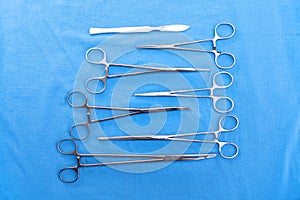 Surgical instruments and tools including scalpels, forceps and tweezers arranged on a table for a surgery