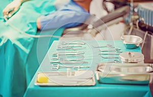 Surgical instruments and tools including scalpels, forceps and tweezers arranged on a table for a surgery, operating room with