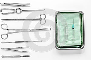 Surgical instruments and tools including scalpels, forceps and tweezers on white table top view