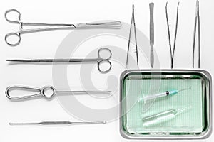 Surgical instruments and tools including scalpels, forceps and tweezers on white table top view