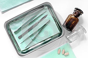 Surgical instruments and tools including scalpels, forceps and tweezers on white table top view