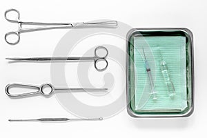 Surgical instruments and tools including scalpels, forceps and tweezers on white table top view