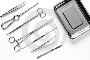 Surgical instruments and tools including scalpels, forceps and tweezers on white table top view mock up