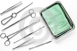 Surgical instruments and tools including scalpels, forceps and tweezers on white table top view mock up