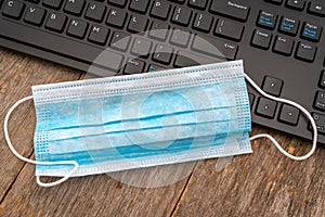 Surgical mask are placed on  computer keyboard