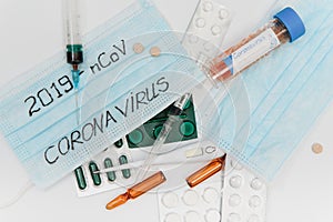 Surgical mask protective mask with CORONAVIRUS text. Virus 2019-n CoV in Wuhan, China. Tablets, mask, syringe