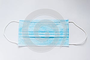 Surgical mask with rubber ear straps. Typical 3-ply surgical mask to cover the mouth and nose.Health protection concept