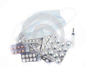 Surgical mask, syringe and many tablets