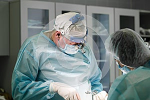 Surgical team performing a cosmetic surgery in hospital operating room