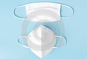 Surgical white mask for wearing germ protection to protect from corona virus set on blue and white  to tone background,top view