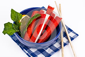 Surimi or crab sticks in blue salad bowl