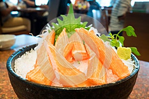 `Surimi` is japanese crab stick sashimi on ice in a black bowl