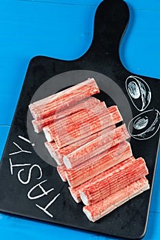 Surimi Sticks On The Black Tray With Tasty Text Sign