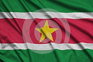 Suriname flag is depicted on a sports cloth fabric with many folds. Sport team banner
