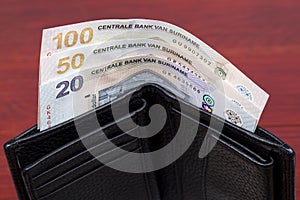 Surinamese dollar in the black wallet photo